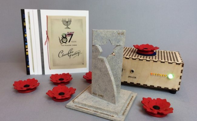A clay trophy, Hanukah card and speaker surrounded by red poppies