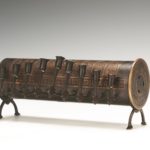 Brown cylindrical Hanukah lamp with feet, front view