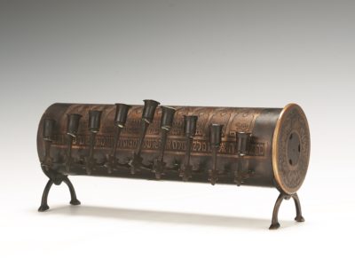 Brown cylindrical Hanukah lamp with feet, front view