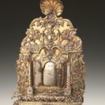 Silver and gold leaf Hanukah Lamp with animal motifs, hinged doors open on front to reveal Hebrew blessing