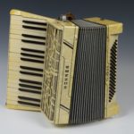 Black and white accordion, piano style keys on left, black buttons on right