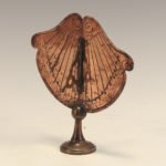 Gold fan shaped sundial on a stand with circular base