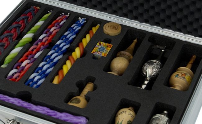 close up open briefcase showing multicolored havdalah candles and spice boxes