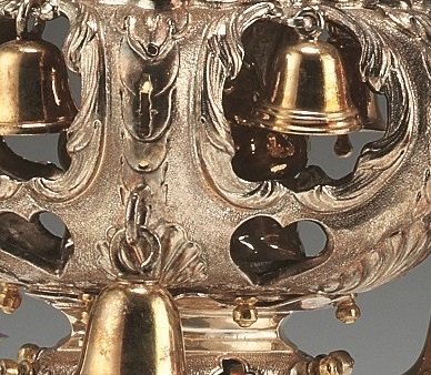 Close up of gold and silver Rimonim (decorations put on top of the Torah) with bells