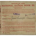 A small brown ration book with red writing.