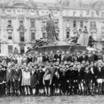 A black and white photograph of 300 children standing in an old town square.