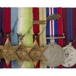 A row of five medals with the Victoria Cross on the left.