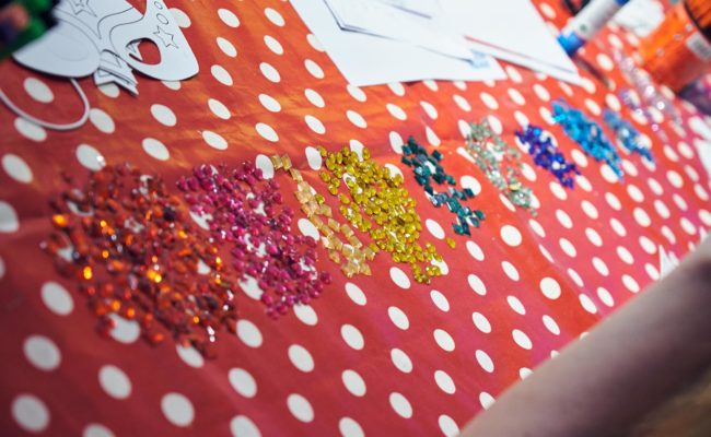Table with polka dot cover and piles of glitter craft gems
