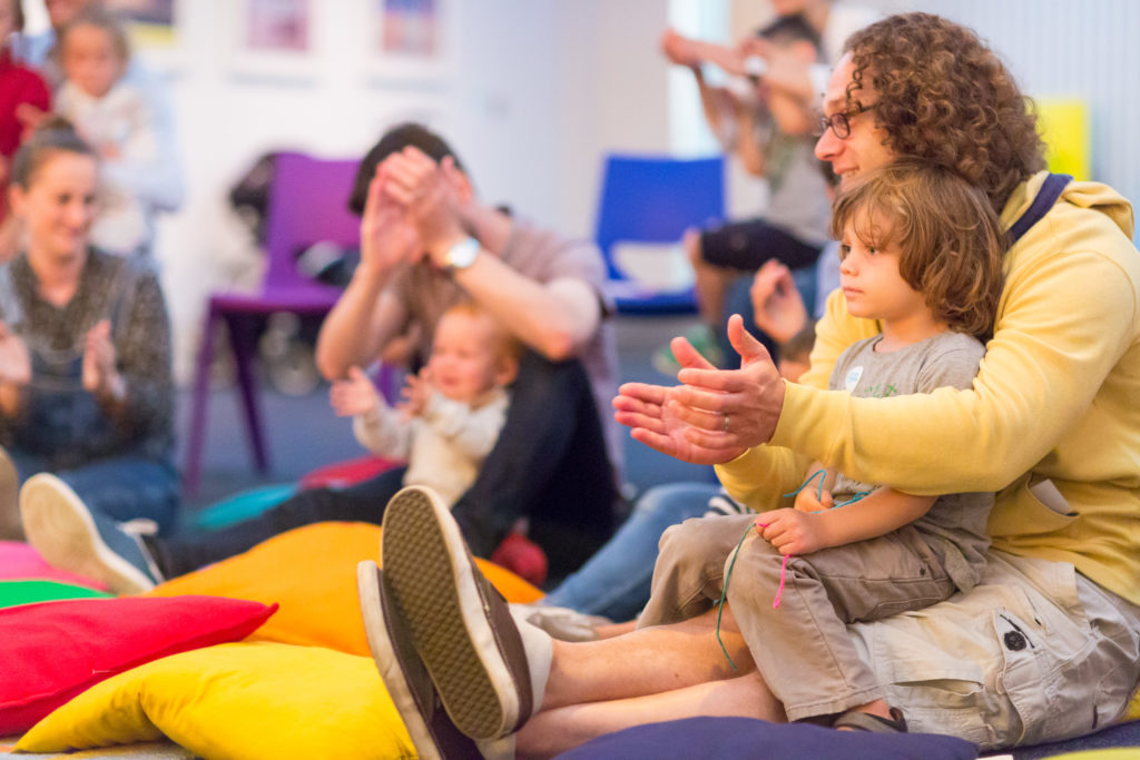 Parent and child clapping and singing at family activity at the Jewish Museum London