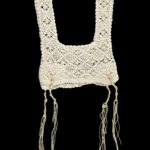 White crocheted vest with tassels at the bottom.