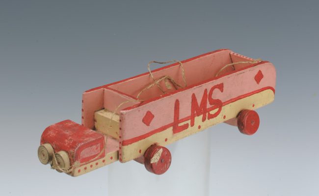 A red and brown wooden truck with the letters "LMS" painted on the side