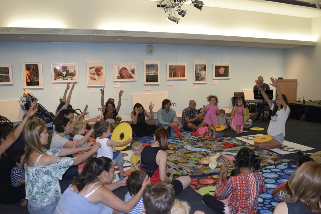 Children and adults sat on the floor in a circle