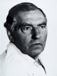 B&W photo of a man wearing a white shirt and looking at the camera 