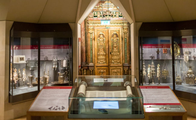 A gallery with glass display cases and a wooden ark