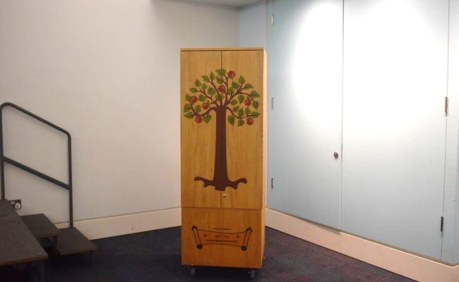A wooden case with a painted front in a blue room