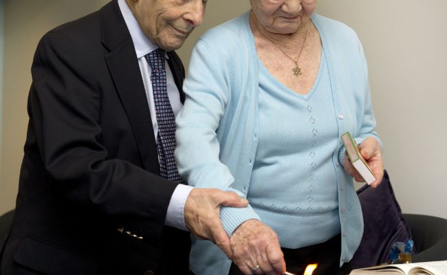 A man and a woman lighting a candle