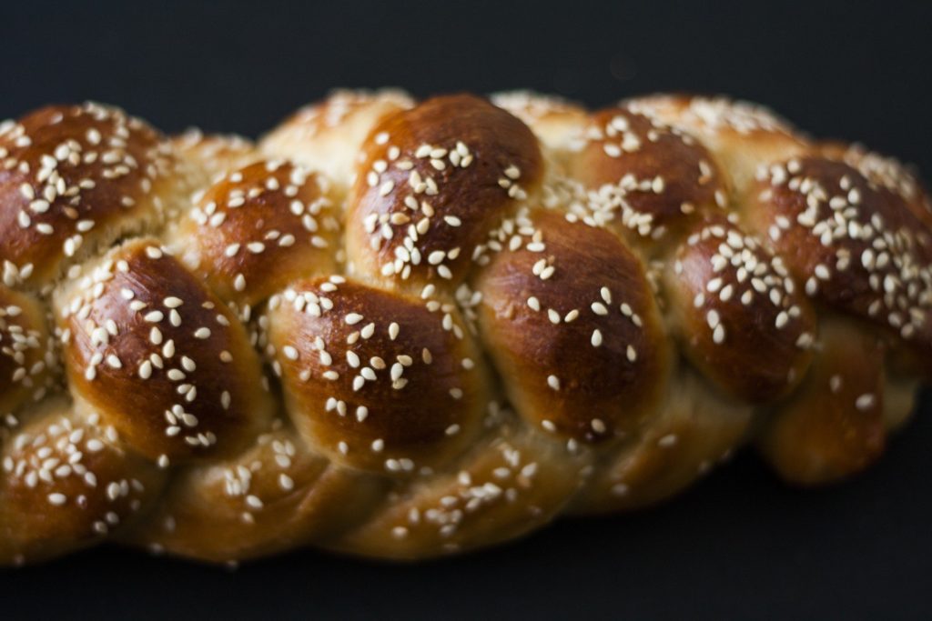 A plaited loaf of bread covered in seeds
