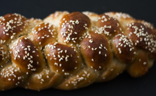 A plaited loaf of bread covered in seeds