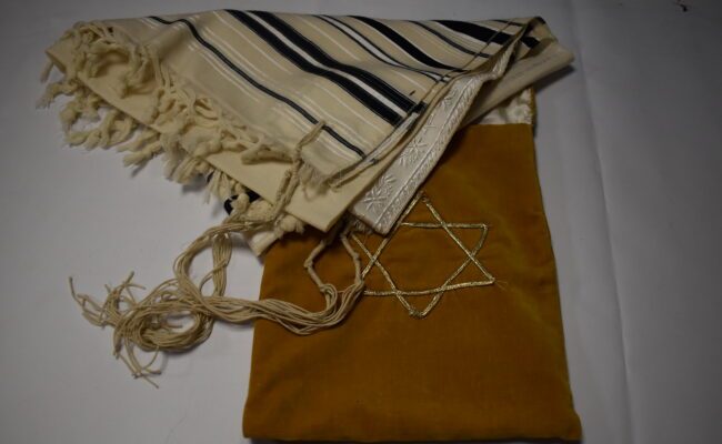 Image of a yellow tallit bag with star of david on it and a Tallit