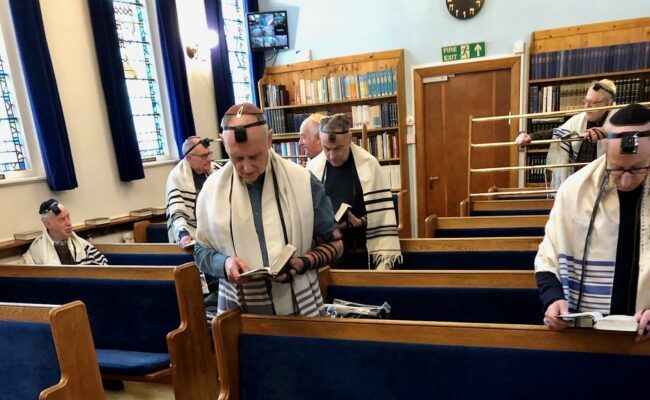 group of Jewish men dressed in traditional clothing praying